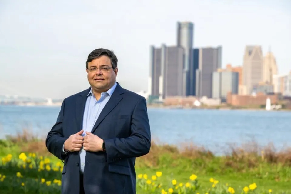 Scott Shireman in front of the Detroit River and the Detroit skyline