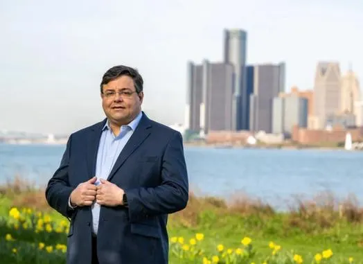 Scott Shireman in front of the Detroit River and the Detroit skyline