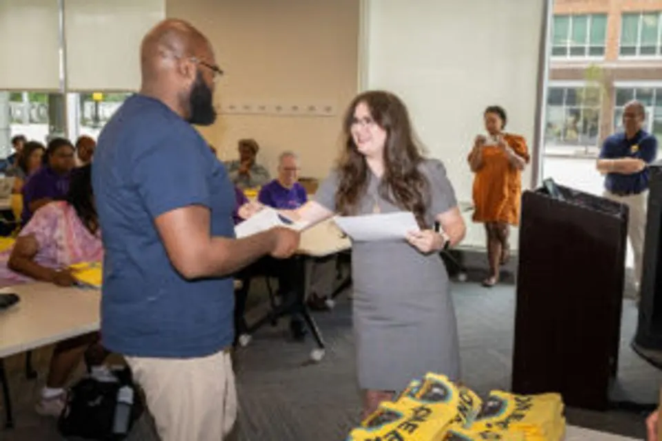 Tamara Qawasmeh handing Rapheal French his certificate
