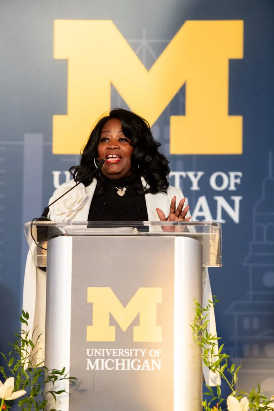 Lisa Phillips, principal of Cass Tech High School, speaks at a lectern with the U-M logo