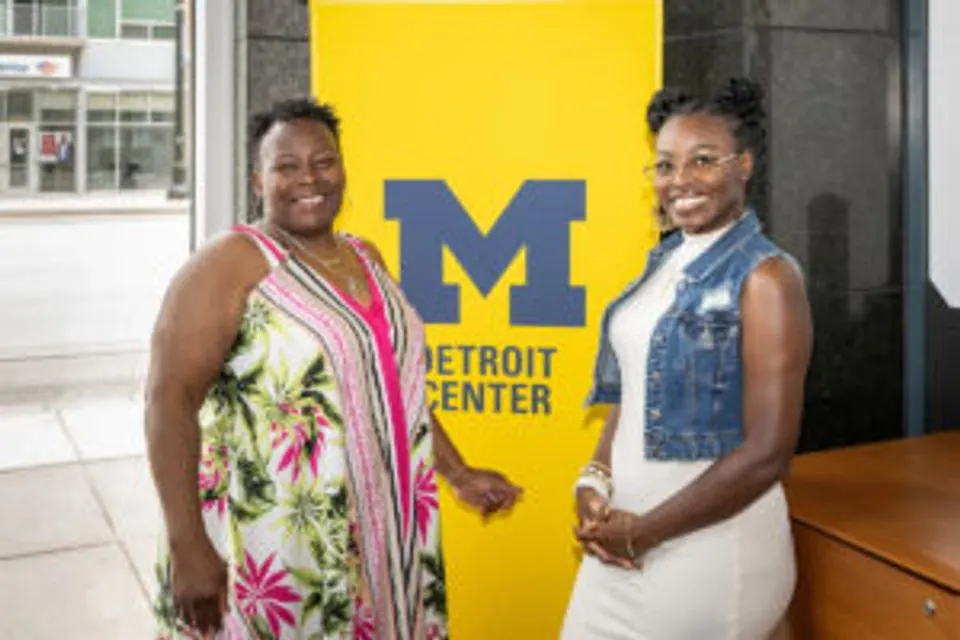 LaCresha Goss and her daughter Selena Goss smiling in from of a U-M Detroit Center sign