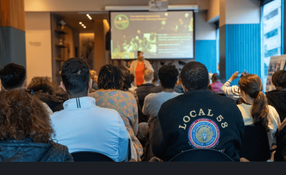 The view from the back of the seated crowd during a presentation